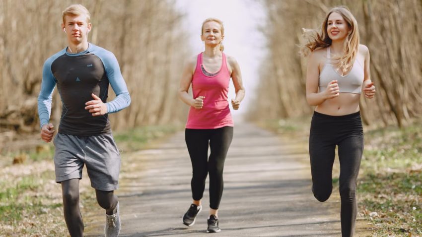 Three adults jogging on a park path, embracing a healthy and active lifestyle.